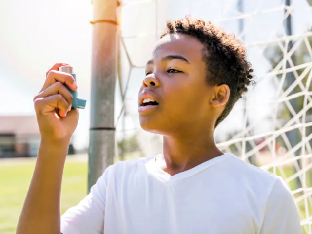 teenager playing soccer with a rescue inhaler