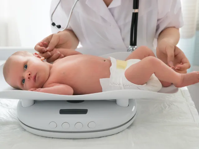 doctor checking a baby's weight